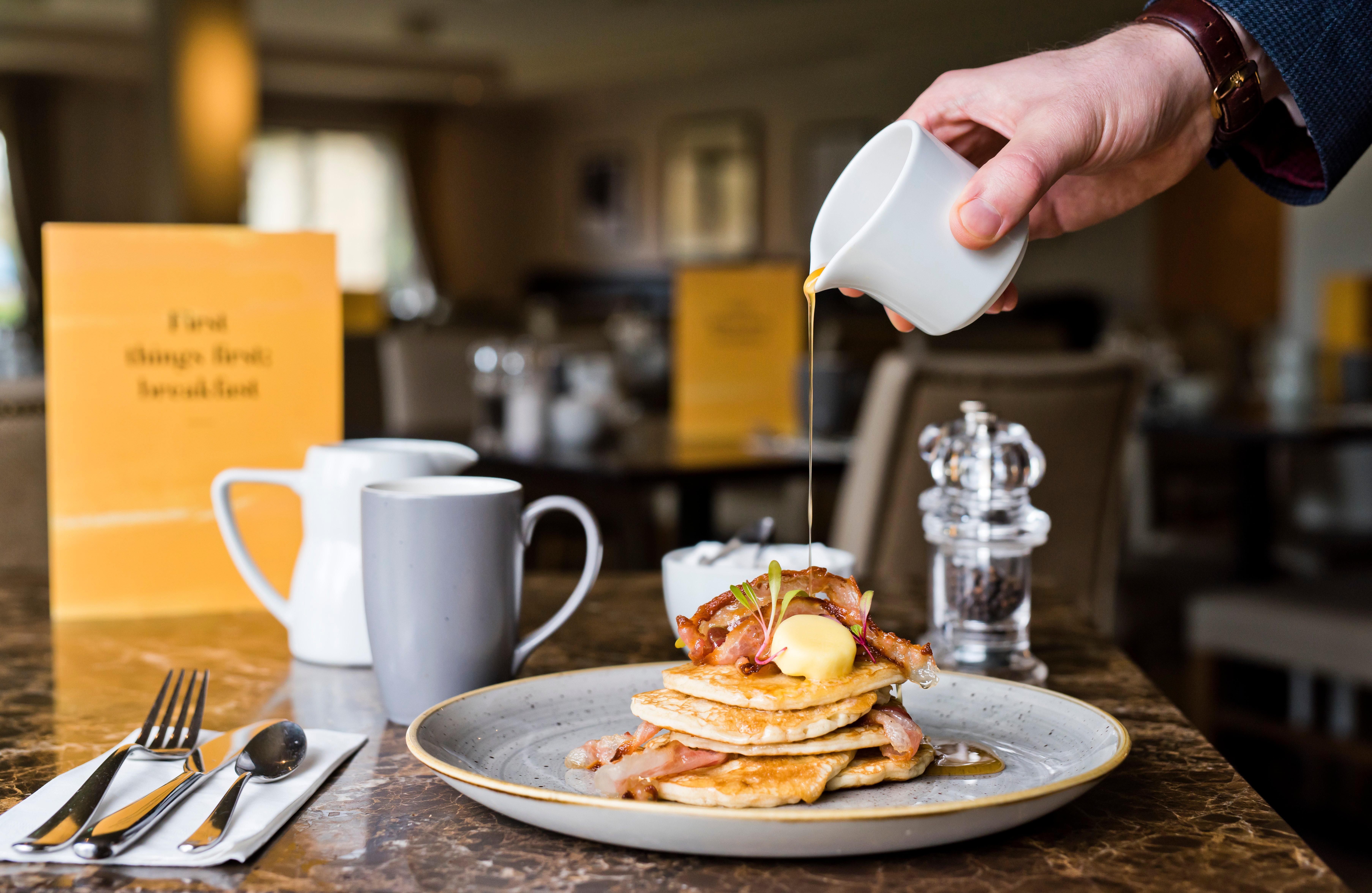 Voco Orchard Singapore By Ihg Exterior foto Maple syrup being poured over a stack of pancakes